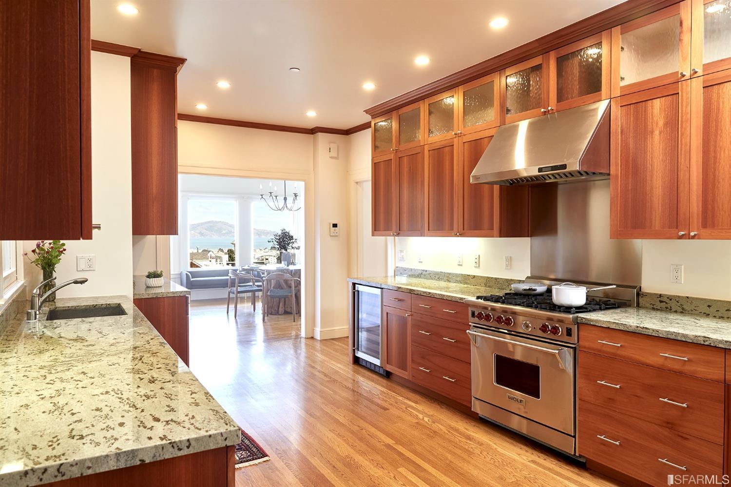 2444 Broadway San Francisco, CA 94115 - Photo 16 of 57 a kitchen with stainless steel appliances granite countertop sink stove and wooden cabinets