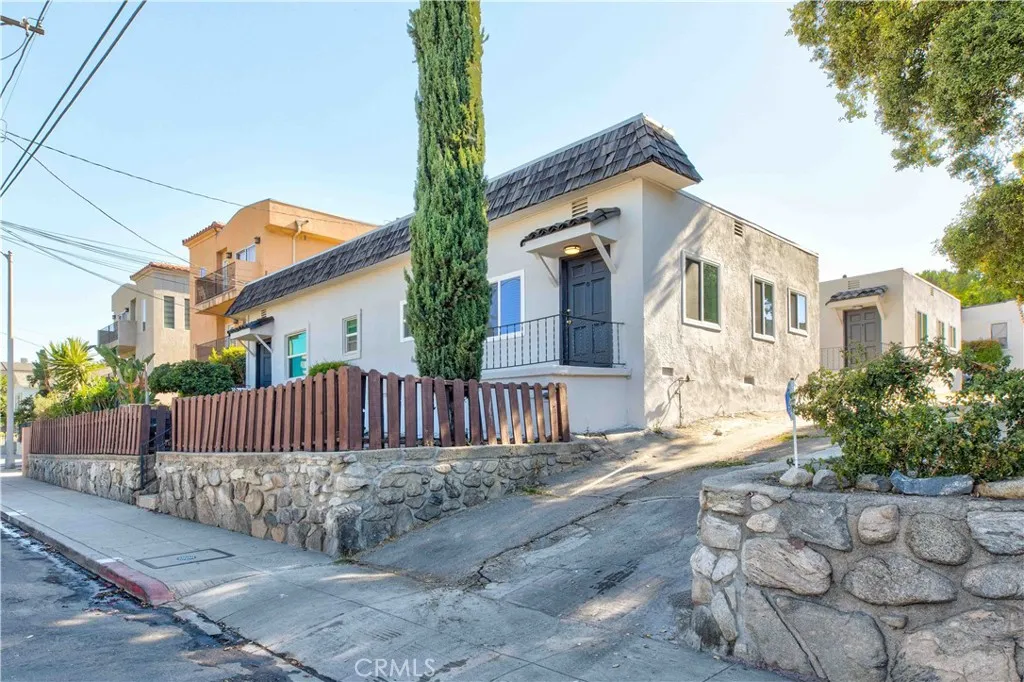 a view of a house with a small yard and wooden fence