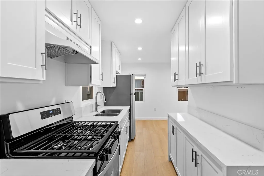 10112 Fernglen Avenue Tujunga, CA 91042 - Photo 3 of 12 a kitchen with stainless steel appliances granite countertop a stove a sink and a refrigerator