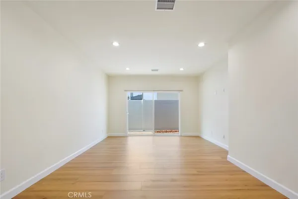 a view of an empty room with wooden floor