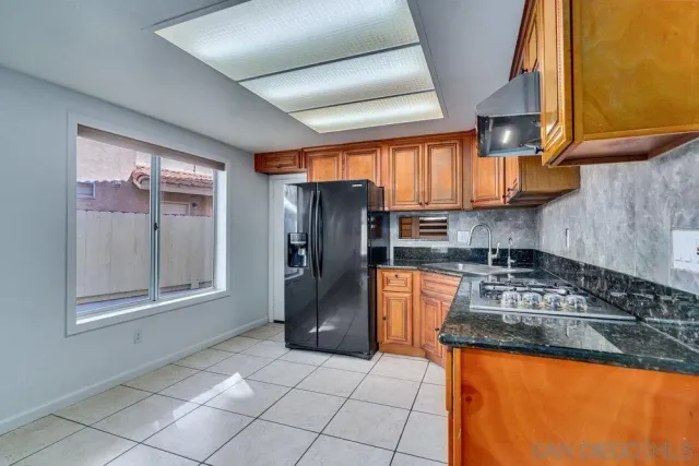 a kitchen with stainless steel appliances granite countertop a refrigerator and a stove top oven