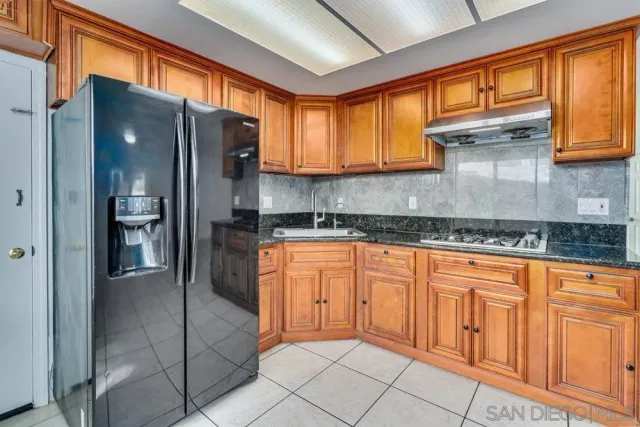 a kitchen with stainless steel appliances granite countertop a refrigerator and a sink