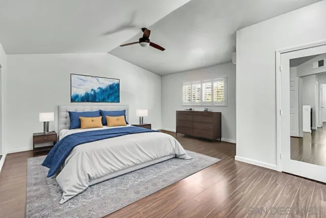 a spacious bedroom with a bed and a painting on the wall