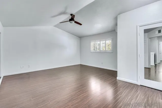 a view of a room with wooden floor and a window