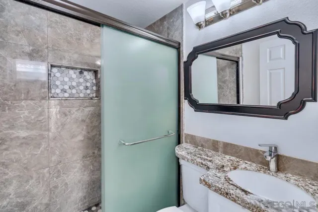 a view of an empty room and chandelier fan