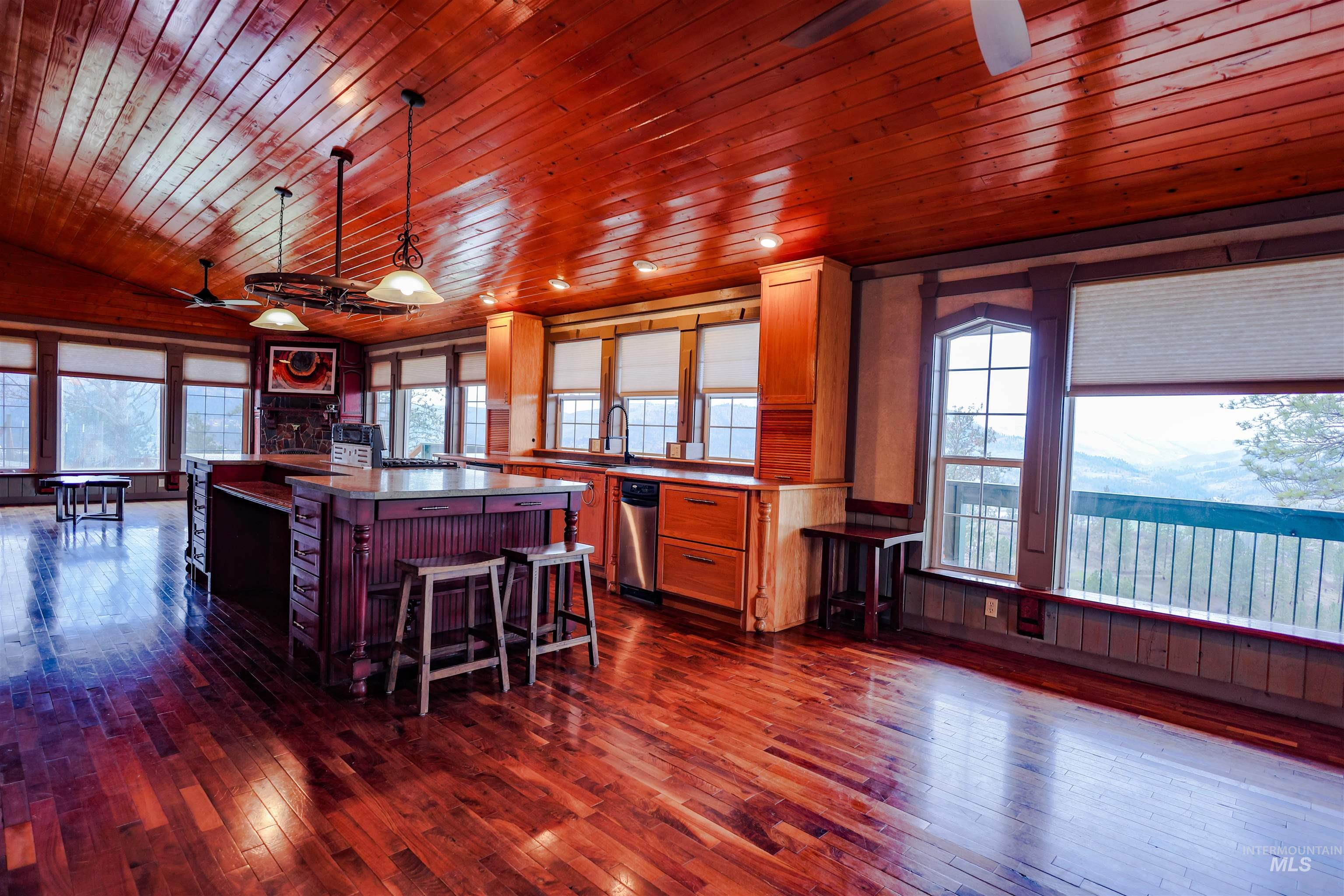 402 Beaverslide Road Kamiah, ID 83536 - Photo 19 of 46 Kitchen featuring a ceiling fan, a center island, dark wood-type flooring, a kitchen breakfast bar, and a vaulted wood ceiling