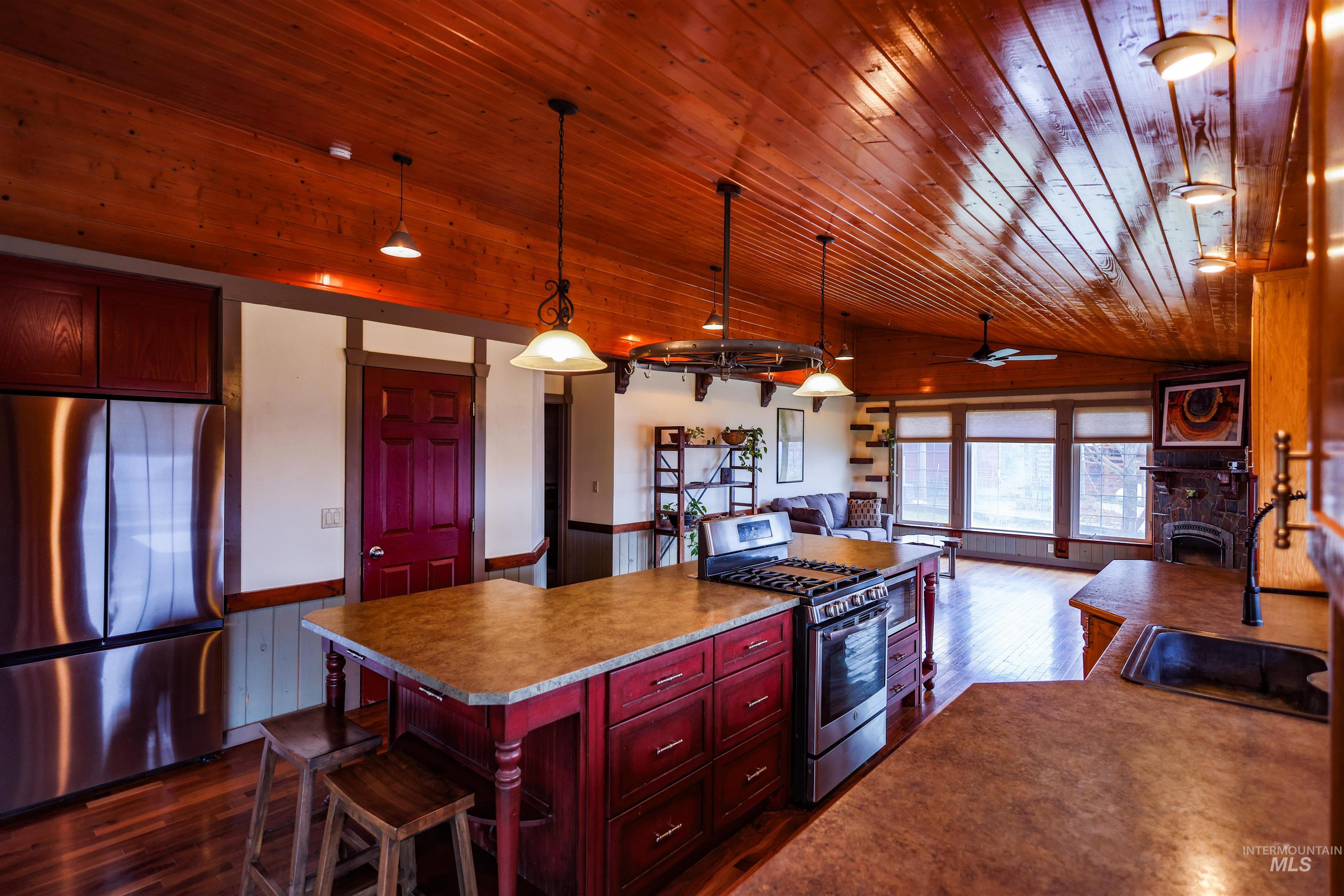 402 Beaverslide Road Kamiah, ID 83536 - Photo 46 of 46 Kitchen with stainless steel appliances, bold wood finish cabinetry, open floor plan, decorative light fixtures, and wainscoting