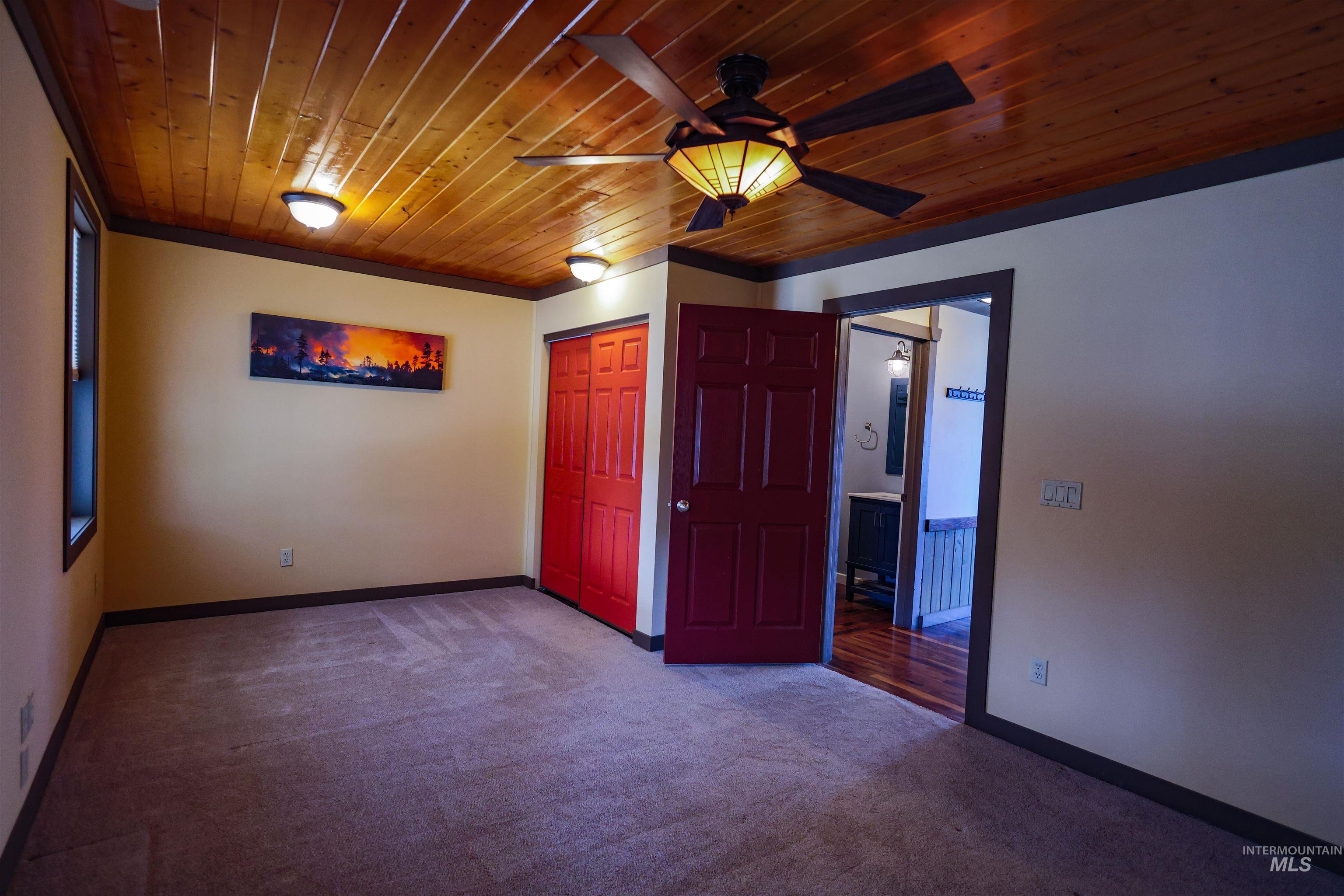 402 Beaverslide Road Kamiah, ID 83536 - Photo 26 of 46 Empty room featuring wooden ceiling, dark colored carpet, and ceiling fan