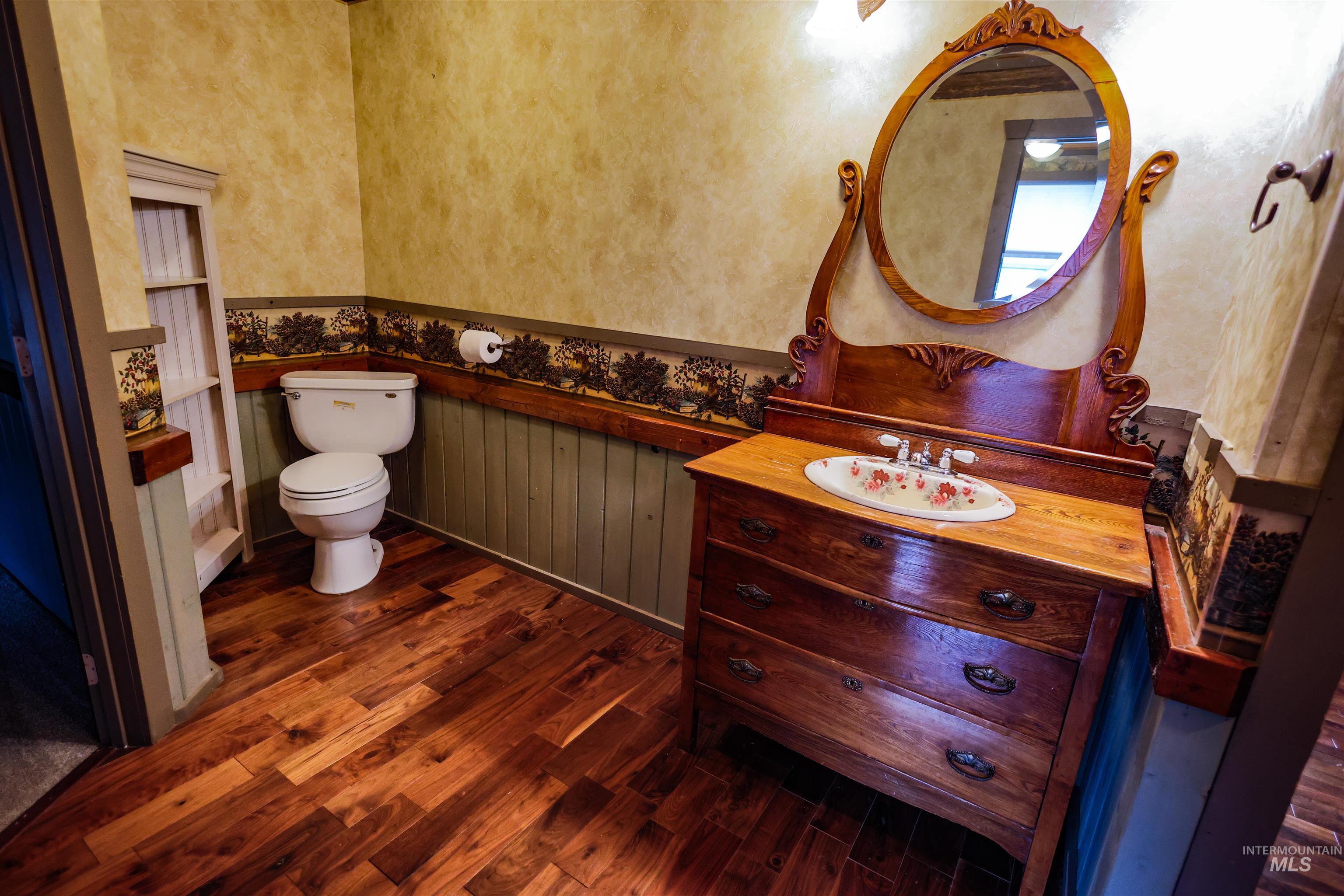 402 Beaverslide Road Kamiah, ID 83536 - Photo 27 of 46 Half bath with vanity, dark wood-style flooring, and a wainscoted wall