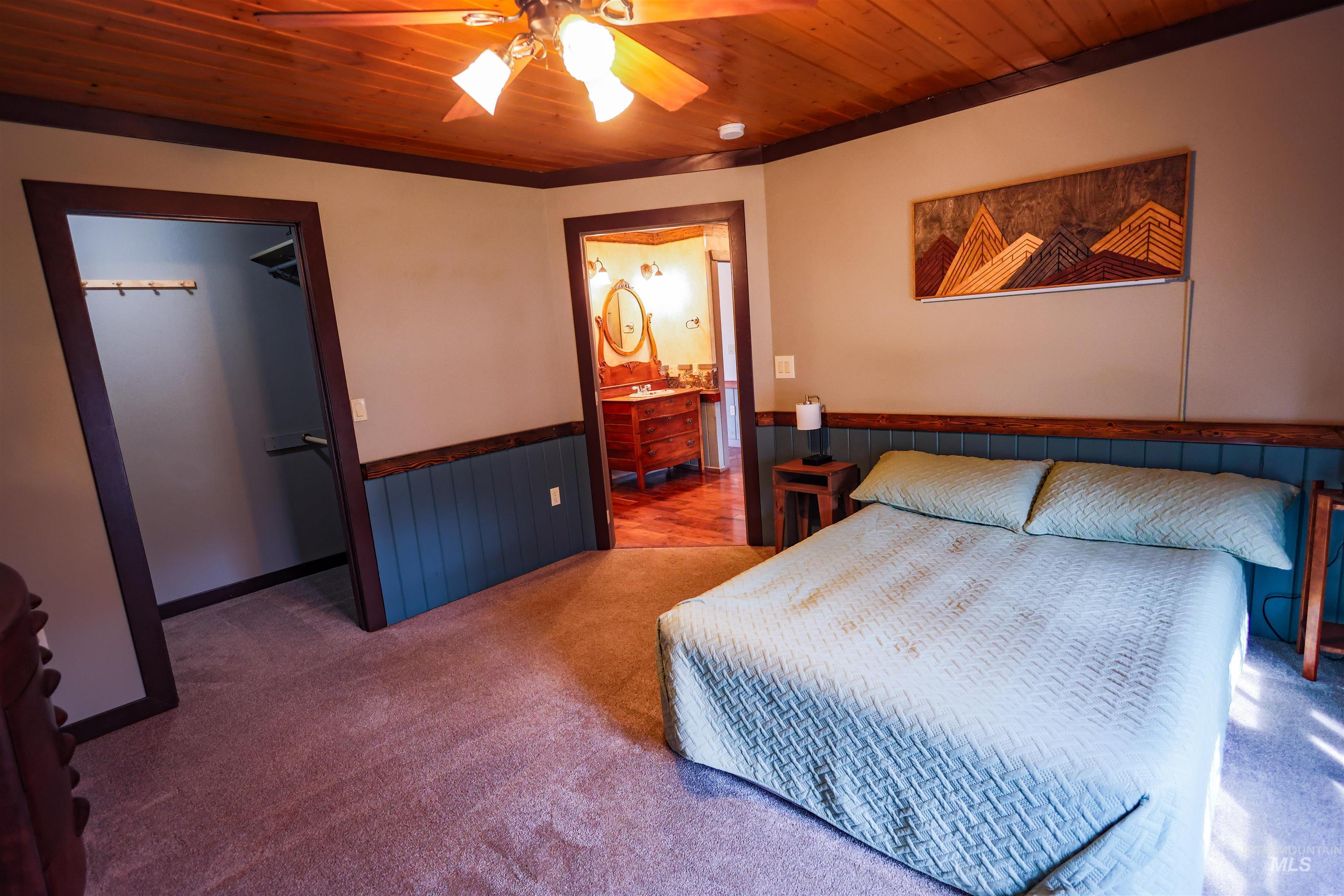 402 Beaverslide Road Kamiah, ID 83536 - Photo 30 of 46 Bedroom featuring carpet floors, a walk in closet, wood ceiling, wainscoting, and a ceiling fan