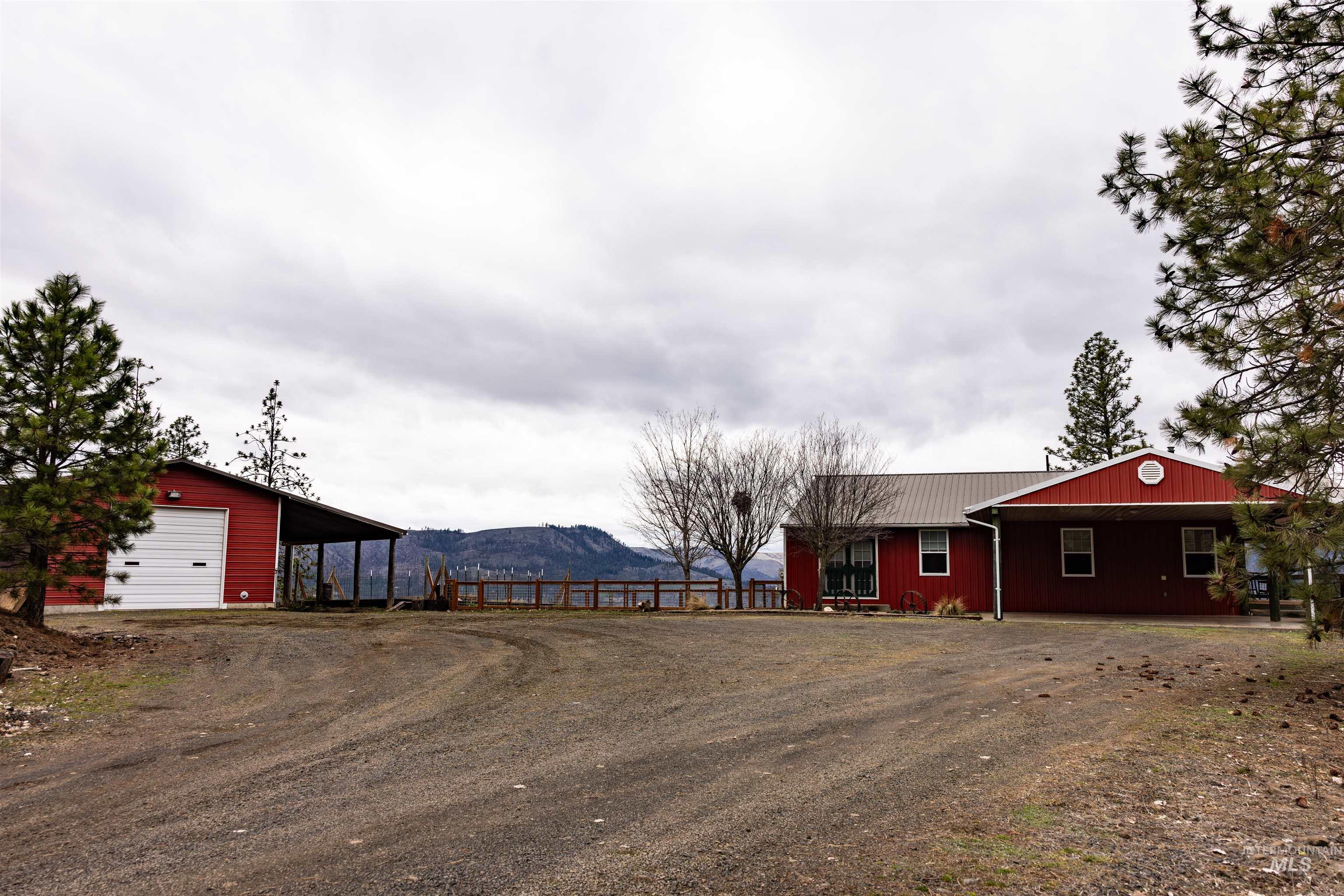 402 Beaverslide Road Kamiah, ID 83536 - Photo 9 of 46 View of front of home with a mountain view, dirt driveway, an outbuilding, and a garage