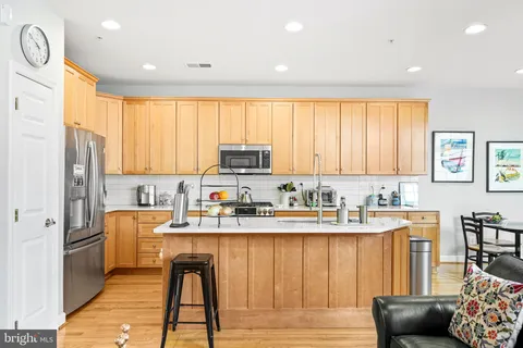 a kitchen with stainless steel appliances granite countertop a refrigerator sink and cabinets