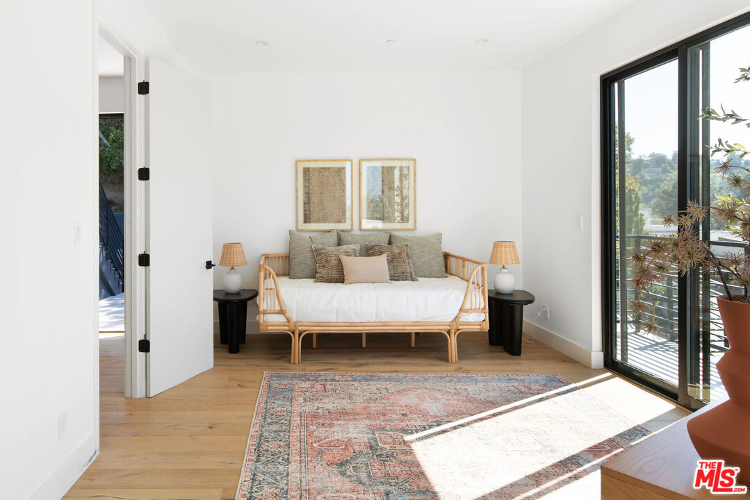 2181 Beech Knoll Road Los Angeles, CA 90046 - Photo 22 of 30 a spacious bedroom with a bed and glass door