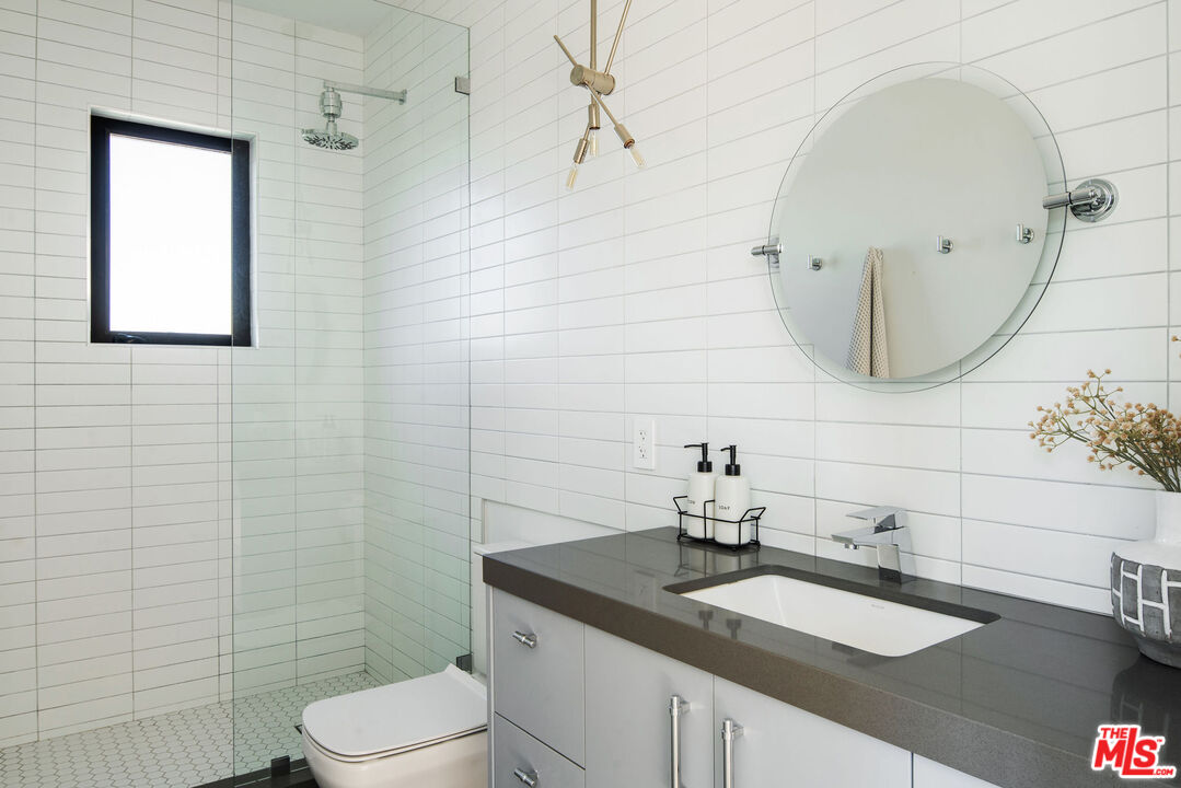 2181 Beech Knoll Road Los Angeles, CA 90046 - Photo 23 of 30 a bathroom with a granite countertop sink a toilet and mirror