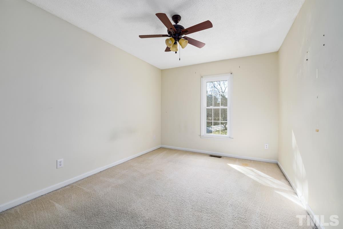 2104 Havering Place Raleigh, NC 27604 - Photo 7 of 13 an empty room with a window and a fan