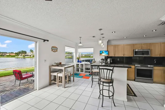 a kitchen with stainless steel appliances kitchen island granite countertop a table and chairs in it