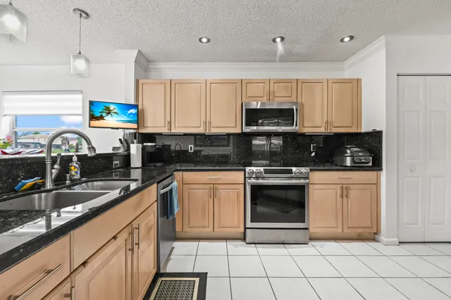 a kitchen with stainless steel appliances granite countertop a sink and a stove