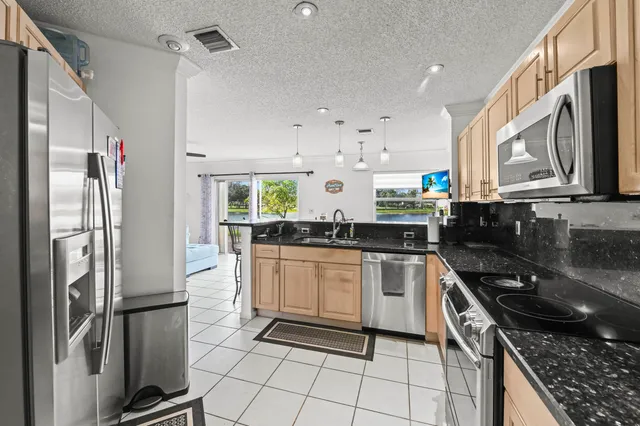 a kitchen with a refrigerator a sink and cabinets