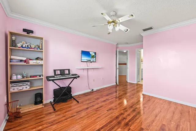 a view of a livingroom with wooden floor and a ceiling fan