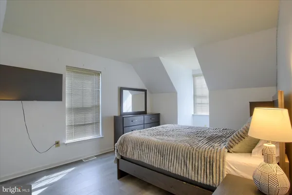 a bedroom with a bed a mirror and lamp