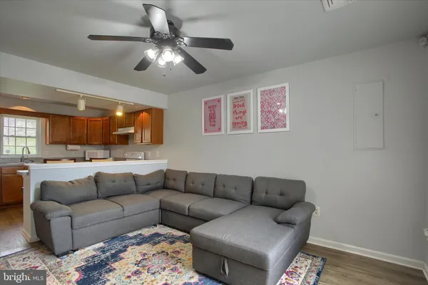 a living room with furniture and a ceiling fan