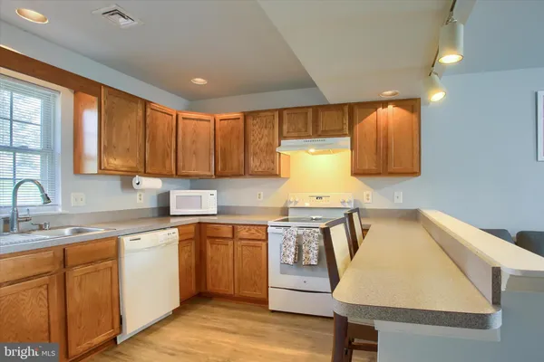a kitchen with a sink a stove cabinets and counter space