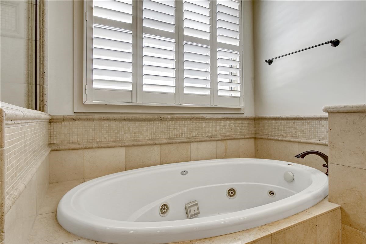 2318 Welch Street Houston, TX 77019 - Photo 26 of 35 Whirlpool jacuzzi tub in primary bath completed with mosaic marble & tuble-stone tile & bronze fixtures