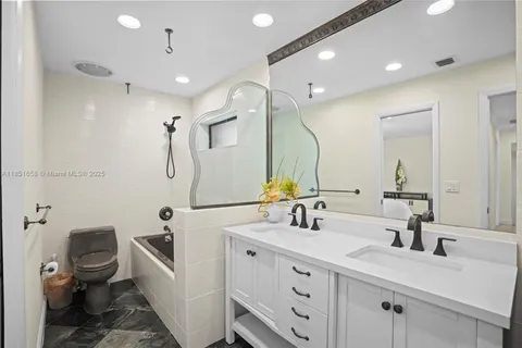 a bathroom with a double vanity sink mirror and toilet