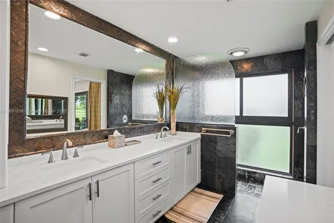a bathroom with a double vanity sink and a large mirror