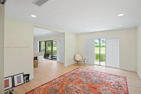 a bedroom with wooden floor and a large window