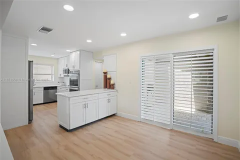a kitchen with white cabinets and white appliances