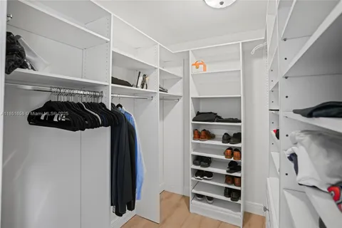 a view of walk in closet with clothes and shoes