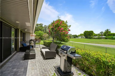 a view of a patio with couches table and chairs and potted plants
