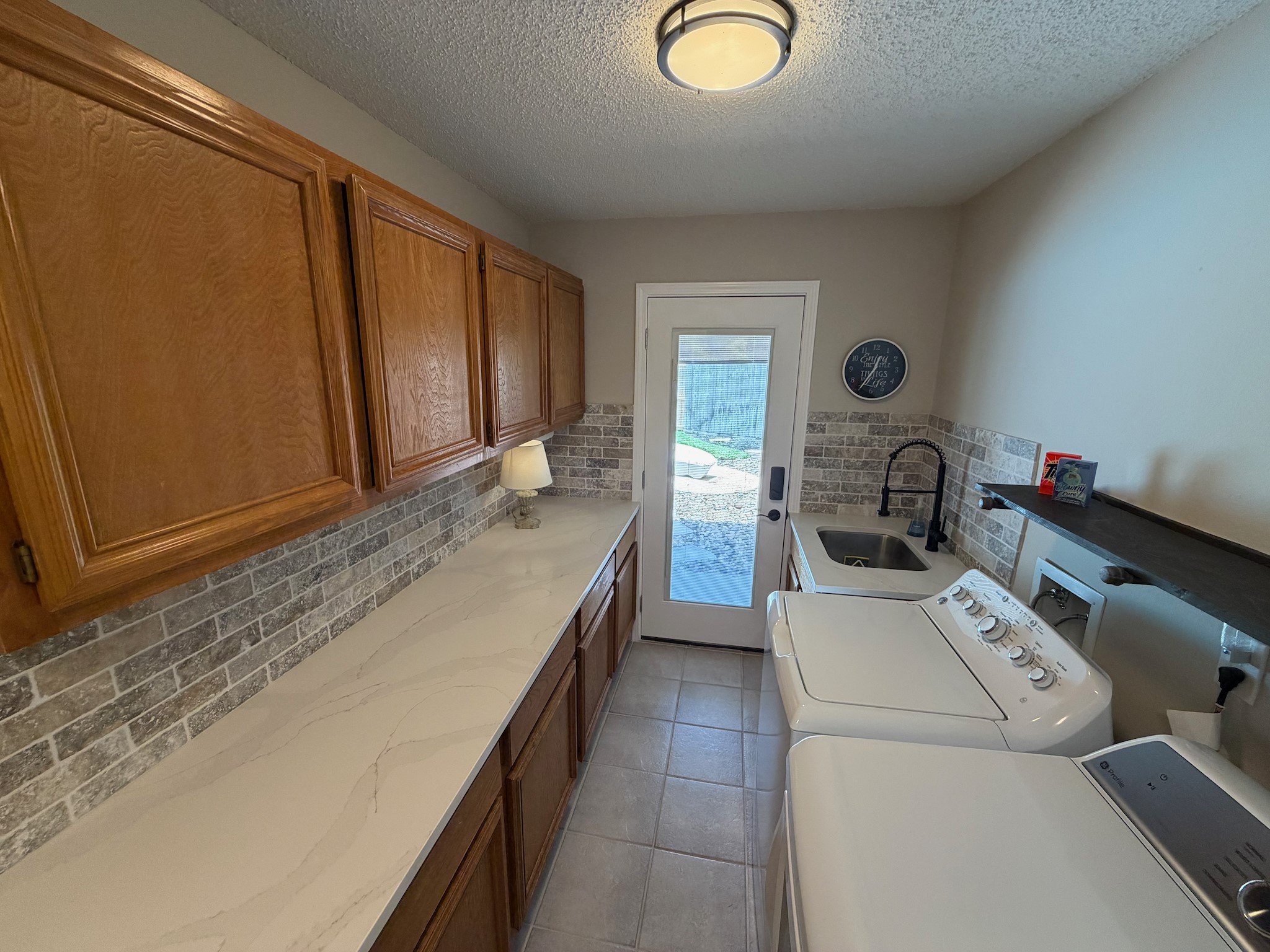 2326 Streamcrest Lane Sugar Land, TX 77479 - Photo 19 of 42 Spacious utility room with ample cabinet storage, sink, and door to backyard pool area.