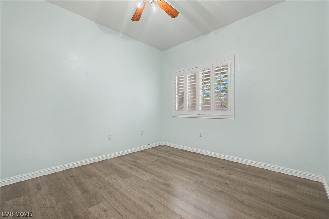 2153 Quarry Ridge Street, Unit 103 Las Vegas, NV 89117 - Photo 5 of 42 Well-lit room featuring durable wood flooring and window shutters for privacy.