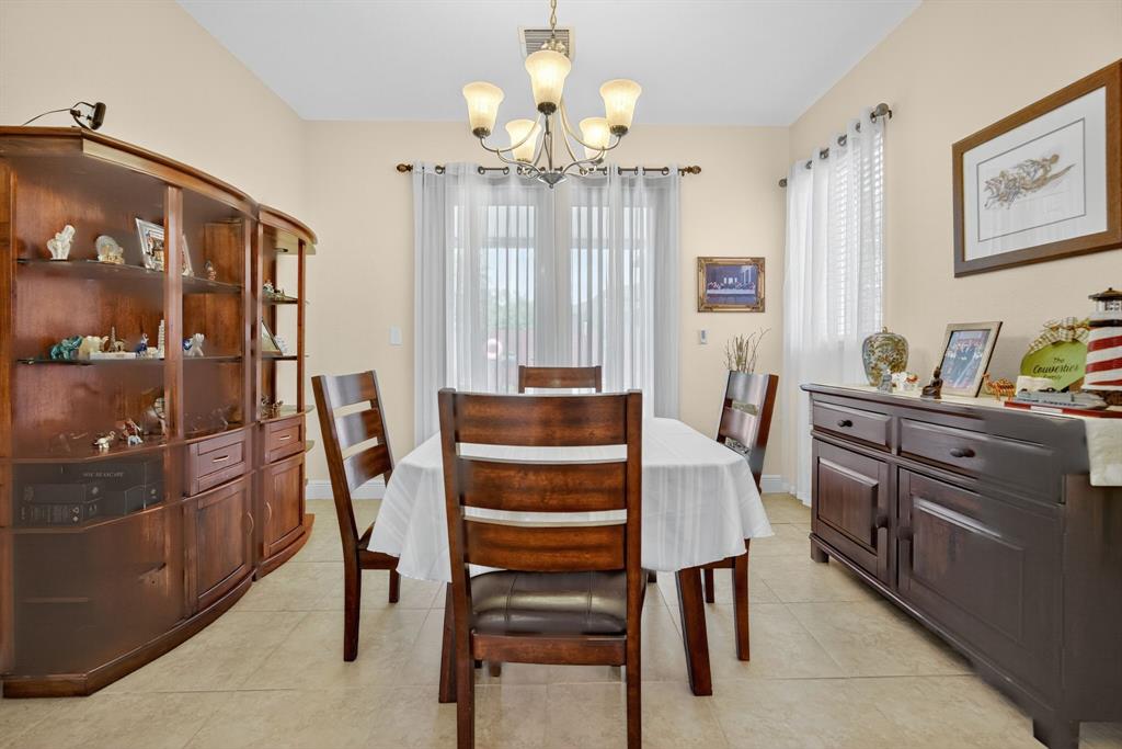 18203 Southwest 152nd Place Miami, FL 33187 - Photo 14 of 55 a view of a dining room with furniture and chandelier