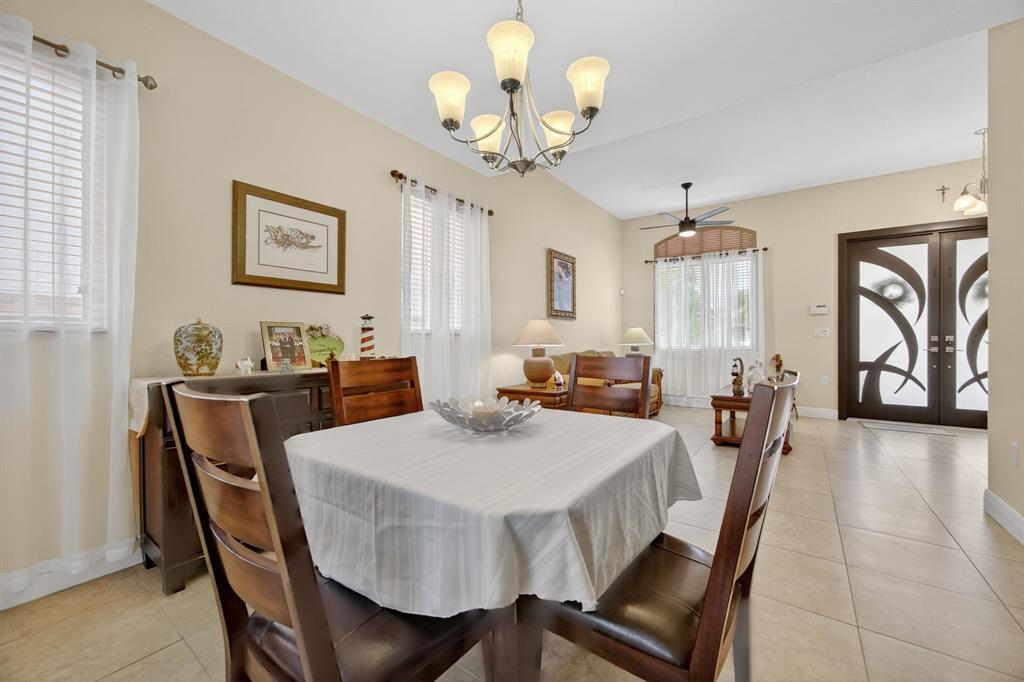 18203 Southwest 152nd Place Miami, FL 33187 - Photo 16 of 55 a view of a dining room with furniture a chandelier and wooden floor