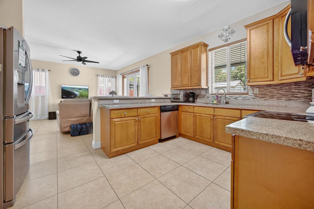 18203 Southwest 152nd Place Miami, FL 33187 - Photo 17 of 55 a kitchen with a sink a counter top space cabinets stainless steel appliances and a window