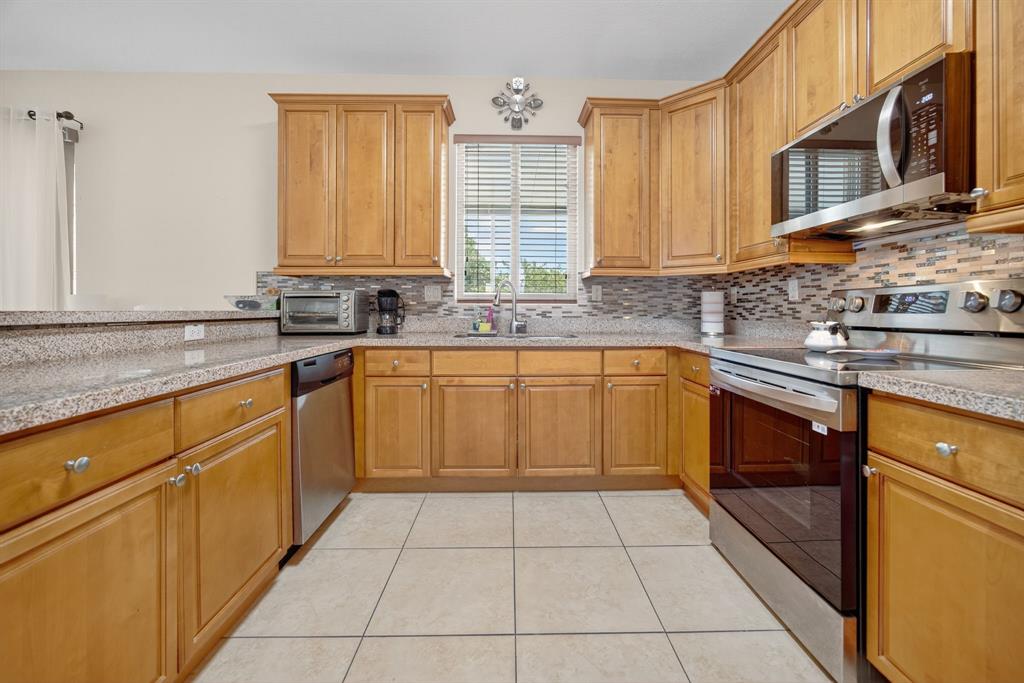 18203 Southwest 152nd Place Miami, FL 33187 - Photo 18 of 55 a kitchen with a sink stove and cabinets