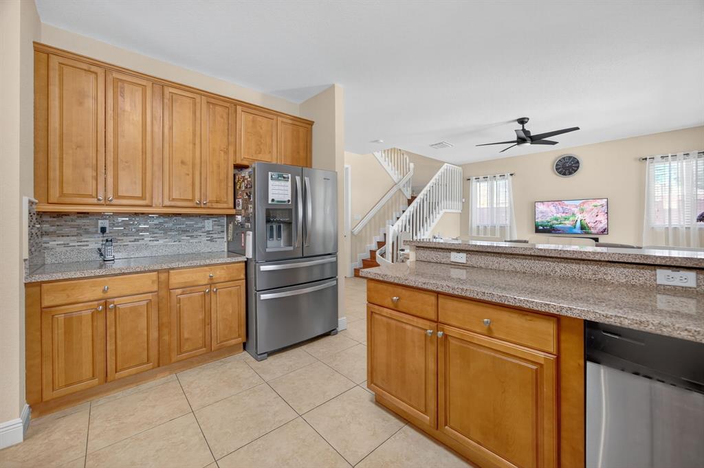 18203 Southwest 152nd Place Miami, FL 33187 - Photo 19 of 55 a kitchen with stainless steel appliances granite countertop a sink and a refrigerator