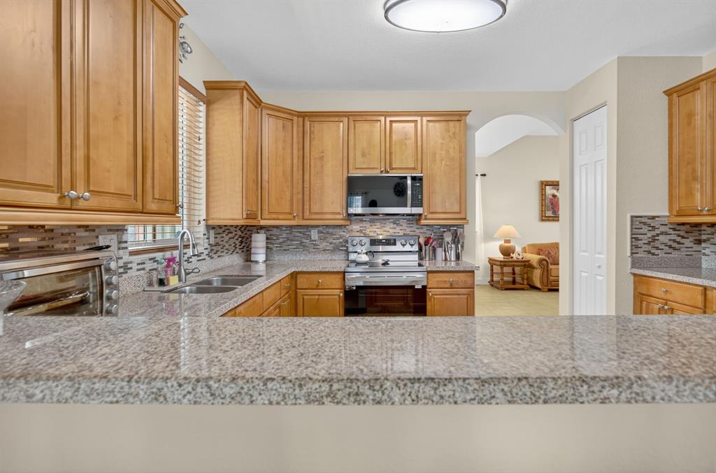 18203 Southwest 152nd Place Miami, FL 33187 - Photo 22 of 55 a kitchen with a stove a sink and a microwave
