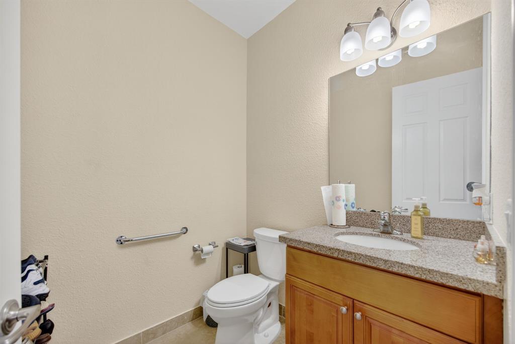 18203 Southwest 152nd Place Miami, FL 33187 - Photo 25 of 55 a bathroom with a granite countertop sink a toilet and a mirror