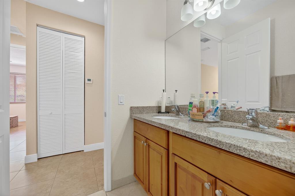 18203 Southwest 152nd Place Miami, FL 33187 - Photo 40 of 55 a bathroom with a granite countertop sink and a mirror