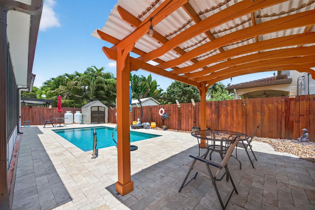 18203 Southwest 152nd Place Miami, FL 33187 - Photo 48 of 55 a patio with glass top table and chairs
