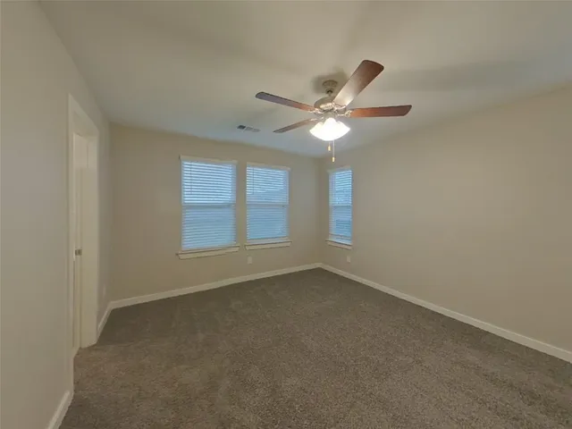 an empty room with a window and a ceiling fan