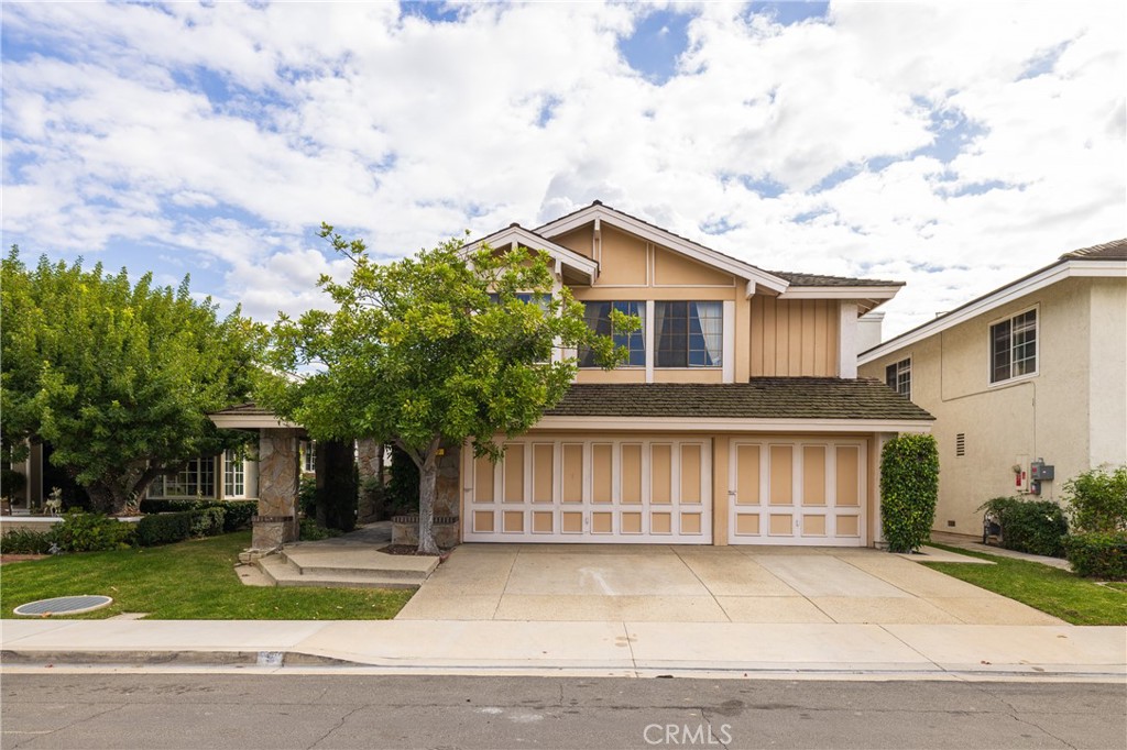 a front view of a house with a garden and trees