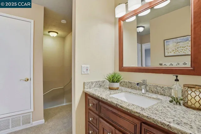 a bathroom with a granite countertop sink and a mirror