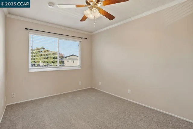 an empty room with a window and a ceiling fan