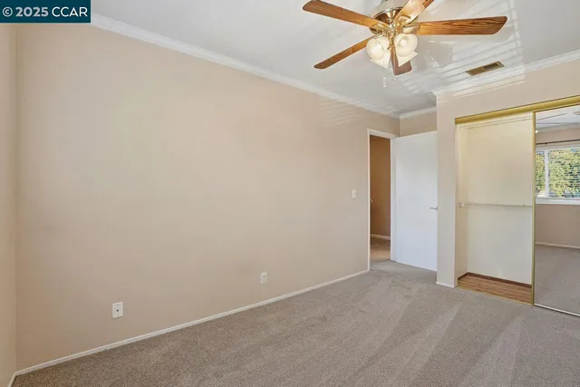 an empty room with a window and a fan