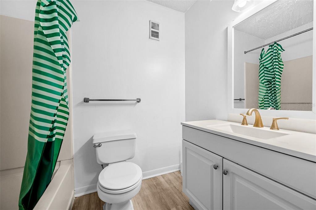 3921 Southwest 34th Street, Unit 208 Gainesville, FL 32608 - Photo 11 of 33 a bathroom with a granite countertop toilet sink and mirror
